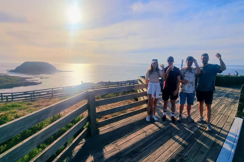 Tour group poses at Nobbies during Golden Hour on the Phillip Island Penguin Parade tour